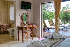 侯斯普瑞特Mawusi Bush Lodge的客房设有书桌、镜子和阳台