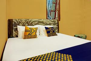 玛琅SPOT ON 92450 Homestay Simpang Panji Suroso Syariah的一张黄色和蓝色枕头的床