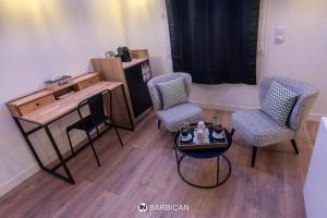维拉尔雷东布Barbican的客房设有2把椅子、一张桌子和一张书桌。