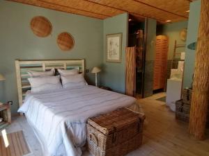 比斯卡罗斯Via Bahia - Maison d'hôtes的卧室配有一张白色大床和木制床头板