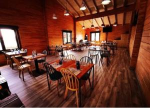 擞莫Kampaoh Somo Parque的餐厅铺有木地板,配有桌椅