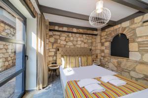 安塔利亚Fiore Garden Suites的一间卧室设有石墙和一张带毛巾的床。