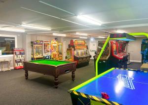 Isle of WhithornBurrowhead Holiday Village的一间设有数种街机游戏和台球桌的房间