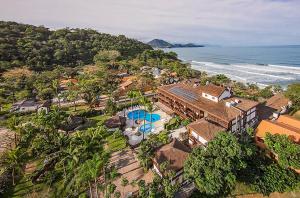 乌巴图巴Hotel Nacional Inn Ubatuba - Praia das Toninhas的房屋和海洋的空中景致