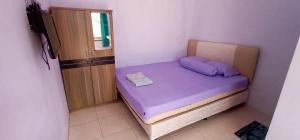 SukobumiBrak Homestay的一间小卧室,房间内设有一张紫色的床