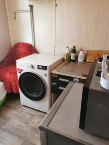 塔林Akadeemia tee appartamendid的厨房配有洗衣机和炉灶。