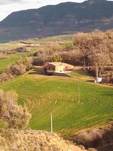 Aransísmasia colomet的山丘中间有房子的田野