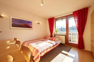 比绍夫斯维森Haus Wendland的一间卧室配有床和红色窗帘的窗户