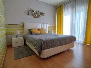 劳林哈Sunset Street Beach house的一间卧室配有一张带黄色窗帘的大床