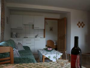 蒂鲁罗Garni Streitlhof的客厅配有一张桌子,并提供一瓶葡萄酒