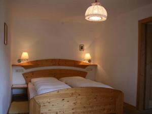 蒂鲁罗Garni Streitlhof的一间卧室配有一张带两个白色枕头的木床