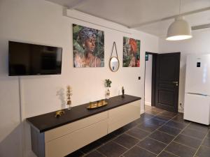 MontjolyAppart Damazonie T3 Idéalement situé的厨房配有黑色柜台,墙上配有电视。