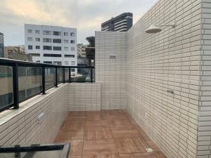 萨尔瓦多Cobertura Armação的铺有木地板,设有白色瓷砖墙壁的阳台。