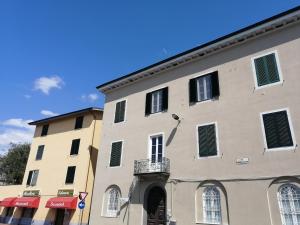 卢卡Casa Sansevera Lucca的一座大型建筑,上面有绿色百叶窗