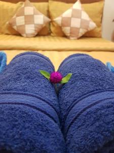 暹粒Bloom Garden Bed & Breakfast的紫色的毯子,上面有粉红色的花