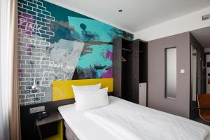 柏林Hotel Berlin, Berlin, a member of Radisson Individuals的一间卧室设有一张床和色彩缤纷的墙壁