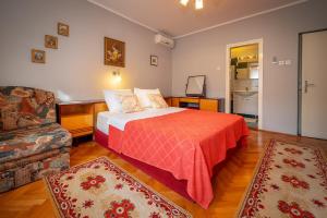 JurandvorRoom Violet的一间卧室配有一张带红色毯子的床和一张沙发