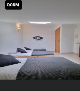 巴勒尔Be Baleal Surfhouse的白色客房内的两张床和两张床
