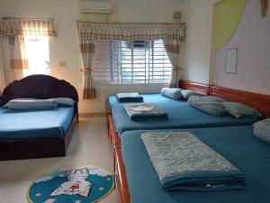 头顿Motel Thanh Huyền的一间卧室设有三张床和窗户。