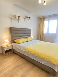 Mataruška BanjaApartman MiNa的一间卧室配有一张带黄色床单的床和一扇窗户。