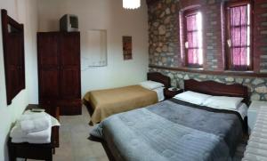 奥吉欧司吉玛洛斯Varnous Hotel的酒店客房带两张床和两个窗户