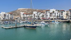 阿加迪尔Apartement Marina Zina, Agadir的一群船停靠在港口,有建筑物