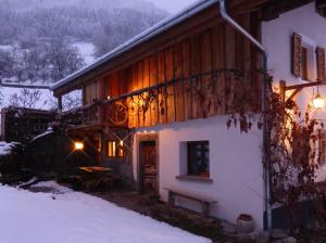 VaillyLa Grange de Pimberty - Beautiful apartments 27 miles from Geneva的雪中的房子,灯亮