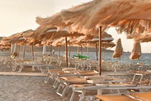 波萨达Sale Hotel的海滩上的一组椅子和遮阳伞