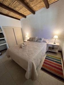 查克拉斯德科里亚Cabaña Chacras de Caro的一间卧室配有一张带两盏灯和地毯的床。