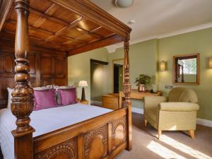 贝德福德The Kingfisher的一间卧室配有一张天蓬床和一把椅子