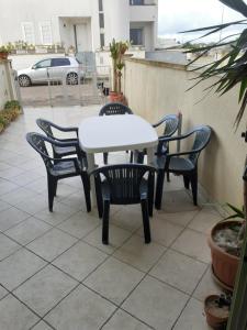 卡萨马塞拉Casa Vacanze Manin的庭院里的白色桌椅