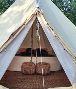 "Žvaigždžių slėnis"- glamping palapinė的白色帐篷,里面设有两张凳子