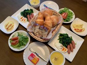 利根pension ぽかぽか（poka poka）的餐桌上放有面包和蔬菜的盘子