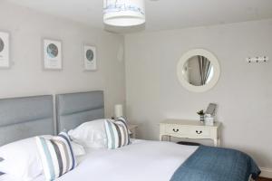 奇切斯特The Bosham Boathouse的一间卧室配有一张床和镜子