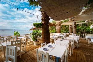 滨海托萨Kampaoh Tossa de Mar的海滩上设有白色桌椅的餐厅