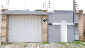 阿奎拉兹Cantinho arretado da Peste - Casa的一个带白色门和砖砌建筑的车库