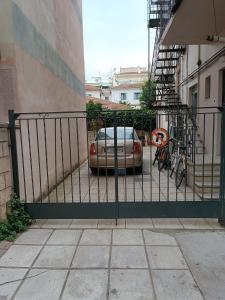 拉里萨Κεντρικό ευρύχωρο στούντιο με parking的建筑物旁的围栏,有停车位