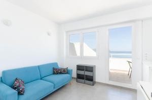 坎皮卡福特YourHouse Monges sea view Studio的客厅设有蓝色的沙发和窗户。