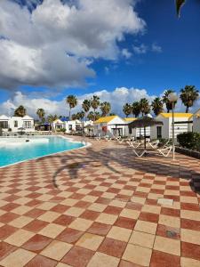 卡勒达德福斯特Casa Azul Montecastillo L7的一个带格子瓷砖地板和游泳池的度假酒店