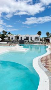 卡勒达德福斯特Casa Azul Montecastillo L7的一座拥有蓝色海水和白色建筑的游泳池