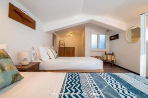 波托菲诺Casa Cristina by PortofinoVip的一间卧室设有两张床和窗户。