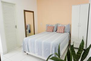 库亚巴Temporada Cuiabana的一间卧室配有一张带蓝色和粉红色枕头的床