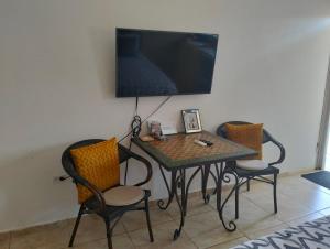 克拉伦代克Marilyn Appartments的一张桌子、两把椅子和墙上的电视