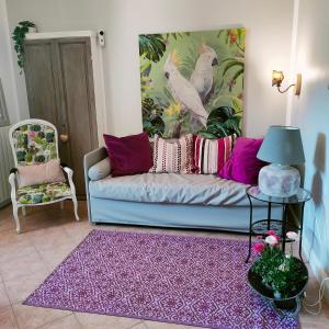 卡斯蒂利翁切洛Suite Eleven的客厅配有蓝色的沙发和紫色地毯