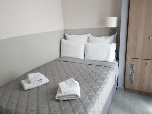 波罗斯Dimitra Boutique Hotel的一间卧室配有带毛巾的床