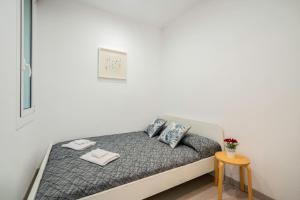 巴塞罗那SAGRADA FAMILIA C&D Lovely Apartment的一张位于白色客房内的床位,配有桌子