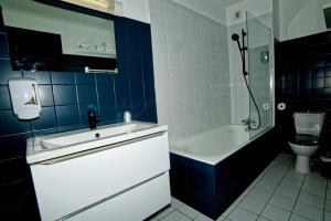 AccousLe Permayou的带浴缸、盥洗盆和卫生间的浴室
