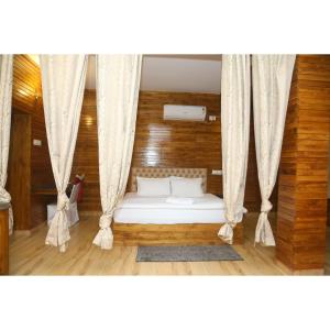 JaypurWoods Residency的窗帘间的床