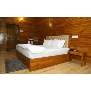 JaypurWoods Residency的一间卧室配有一张带木墙的大床