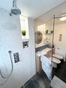 SurbitonBeautiful 2 bedroom garden flat w/ free parking的带淋浴、盥洗盆和卫生间的浴室